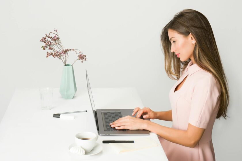 Woman in Pink Dress Using Laptop Computer